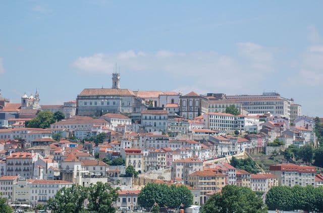 Panoramic view of Coimbra's historic cityscape with iconic architecture on a sunny day.