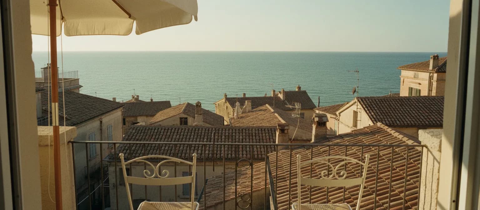 Terracotta rooftops and a shaded terrace looking out to the sea